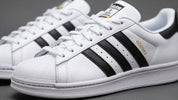 Pantofi sport Adidas Superstar cu dungi negre.